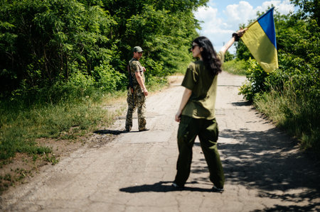 Zaporizhzhia, Ukraine July 1, 2022: Ukrainian military defender with his wife, portrait of a young couple where the man is a soldier, the man is with a weapon.のeditorial素材