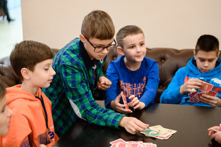 Ivano-Frankivsk, Ukraine November 20, 2022: Children play board games, playing cards with children on birthday holidays, educational games.のeditorial素材