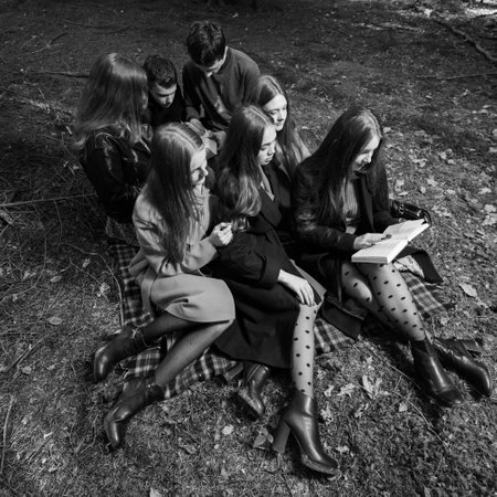 Ivano-Frankivsk, Ukraine October 14, 2022: teenage schoolchildren reading a book in the forest, a group of children in the park, a group of classmates in the autumn forest.のeditorial素材