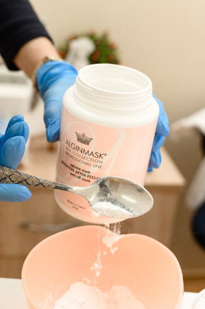Ivano-Frankivsk, Ukraine December 20, 2022:Preparation of a moisturizing mask by hand, powder for the preparation of a moisturizing mask, the work of a cosmetologist.のeditorial素材