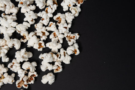 fried popcorn on black background close-up, ready-to-eat food, corn cooking method, copy space and black background with popcorn.の写真素材