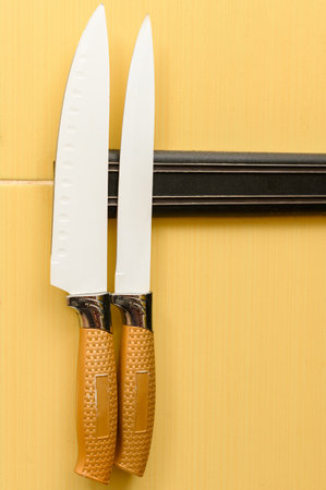 Two large knives on magnetic tape hang on the wall, kitchen knives.の写真素材