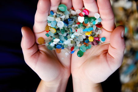 A person holds recycled plastic granules in his hands close-up, human plastic recycling, generative AI.の素材