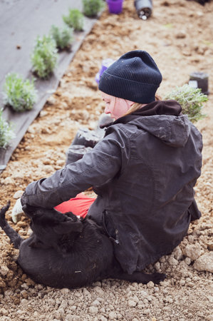 Woman playing with dog and planting lavender, pet and lavender.