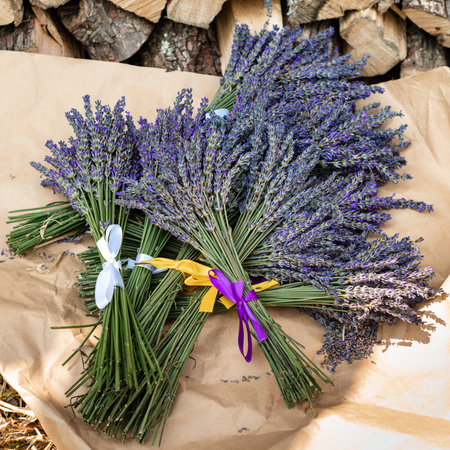 Lavender bouquets with purple and yellow ribbons lie on kraft paperの写真素材