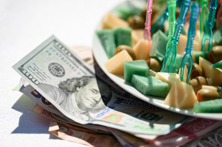 Dollars 100 bill and hryvnias lie on the table, next to the money is a cheese snack.の写真素材