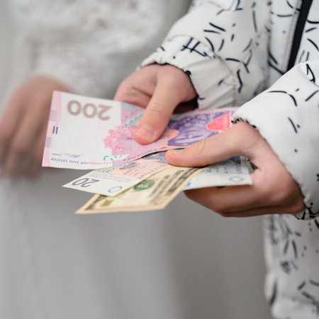 The child holds Ukrainian hryvnias, Polish zlotys and American dollars in his hands