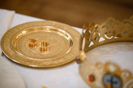 Wedding rings stand on a tray in the church for consecration with water, religious rites with rings for brides.の写真素材