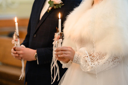 The bride and groom hold lit candles in their hands, wedding traditions.の写真素材