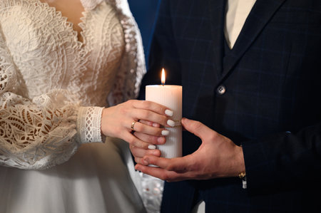 The bride and groom hold lit candles in their hands, wedding traditions.の写真素材
