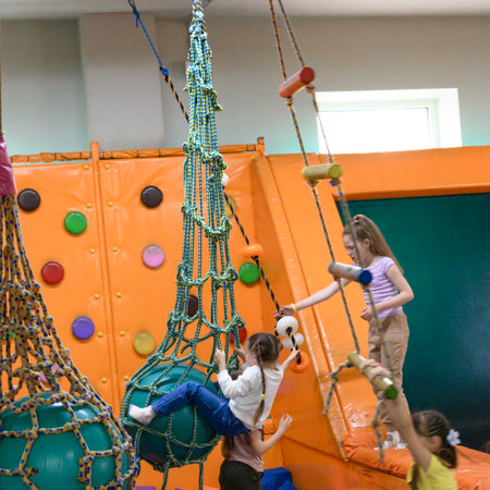Ivano-Frankivsk, Ukraine June 7, 2023: A child rides a rope over a pool of soft cubes.のeditorial素材