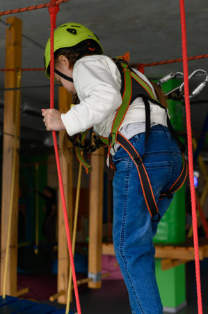 active and physical development of the child, the girl passes the cableway in the playroom.
