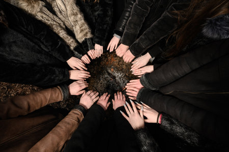 children's hands are folded with palms up in a circle, hands are held over the fire.