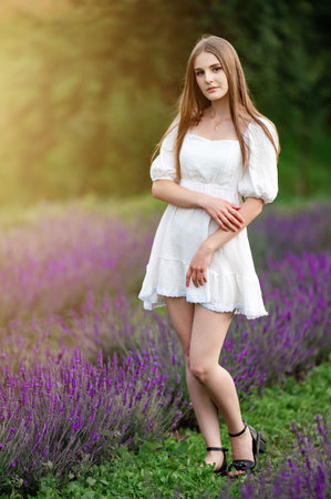 Ivano-Frankivsk, Ukraine July 28, 2023:A beautiful girl in a white dress walks through a lavender fieldのeditorial素材