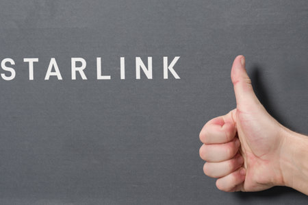 Ivano-Frankivsk, Ukraine December 2, 2023: Box from starlink antenna with logo, man finger points...