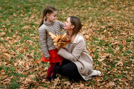 Autumn portrait of mother and daughter in the park, happy mother and daughter.の写真素材