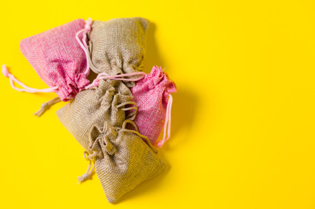 Lavender flower in a linen bag on a yellow background, fragrant lavender sachet.の写真素材
