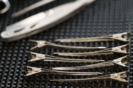 Hair clips on a black barber's workspace close-up.