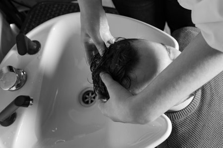 Barber shampooing washing a male clients head in the sink.の写真素材