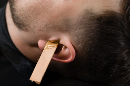 Ear hair wax removal. Hair removal procedure in a barbershop.の写真素材