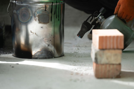 The method of heating resin in a bucket using a kerosene lamp at home, waterproofing the floor with resin.の写真素材