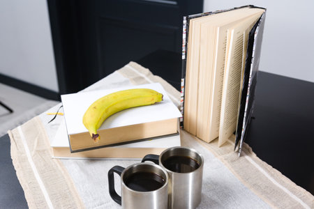 Books, banana, and coffee on a tableの写真素材