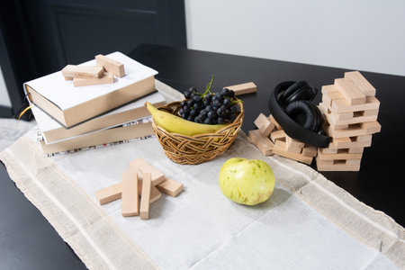 Still life with books, fruit, headphones, and wooden blocks on a table.の写真素材