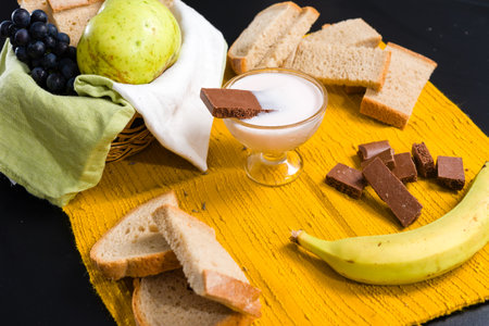 Breakfast spread with fruit, bread, yogurt, and chocolate.の写真素材