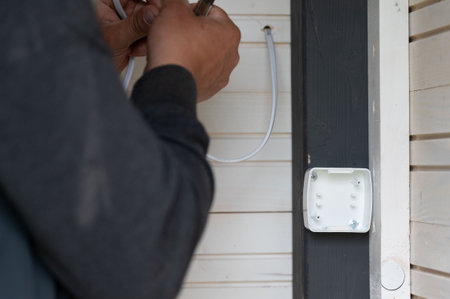Stripping electrical wires and installing switches in a gazebo in the garden, working with electrical wires.の写真素材