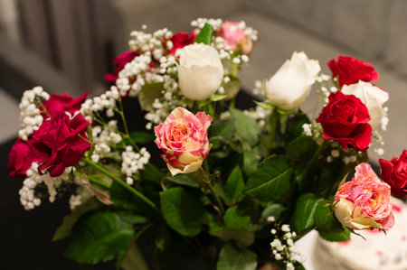 Close-up of a beautiful bouquet featuring various rose colors and baby's breath. The roses are arranged to showcase their vibrant hues and delicate textures.の写真素材