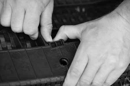 Close-up of hands assembling a plastic component.  Detailed view of intricate parts and precise movements.の写真素材