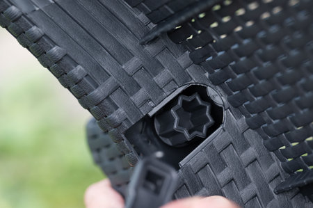 A detailed view of a plastic connector for outdoor furniture. The image showcases the woven texture and the fastening system.の写真素材