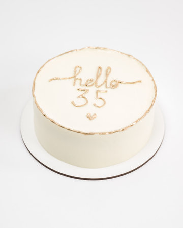Elegant small cake with 'Hello 35' in gold lettering, perfect for a birthday celebration.の写真素材