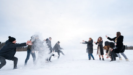 Ivano-Frankivsk, Ukraine January 12, 2024:Friends enjoying a snowball fight in a snowy field. Laughter and winter fun.のeditorial素材