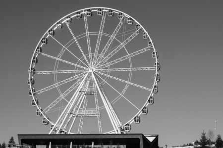 A towering giant wheel stands proudly against a clear backdrop, offering panoramic views to both adventure lovers and families enjoying a day of fun.の写真素材