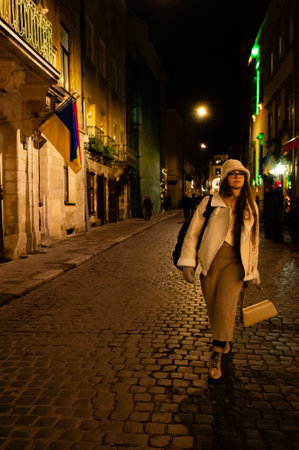 A lone figure walks gracefully along a cobblestone street, adorned with colorful flags and soft lights, capturing the serenity of a calm night in the city.の写真素材
