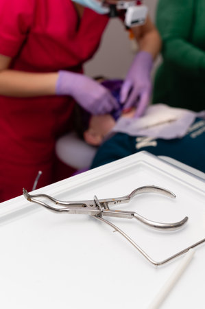 Highly skilled dental professionals focus on a patient while utilizing advanced tools, ensuring a safe and efficient dental procedure in a clean, well-lit clinic setting.の写真素材