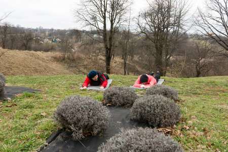 Group of individuals are practicing wellness activities on a hillside, surrounded by lush greenery and unique plant formations, embracing a calm and refreshing atmosphere.の写真素材