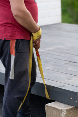 Workers use a fabric rope to move the gazebo frame to a permanent location, moving the gazebo...