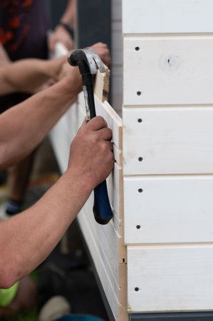 Installing and aligning boards in grooves when installing a wall in a gazebo, construction work and moments during the construction of a gazebo.の写真素材
