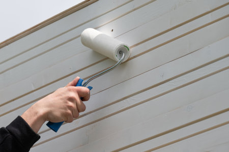Repainting the wall white with a roller, painting wooden walls.の写真素材
