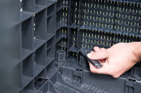 Close-up of hands assembling a dark gray plastic storage unit. The modular design allows for flexible configurations. Easy connection system.の写真素材