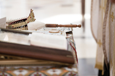 Close-up of religious artifacts: a golden crown and a wooden brush with white fibers, placed on an ornate table. The setting appears to be a church or religious space.の写真素材