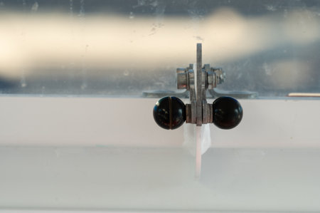 Focusing on a sleek metal latch, sunlight glints off its surface, highlighting the elegant design...