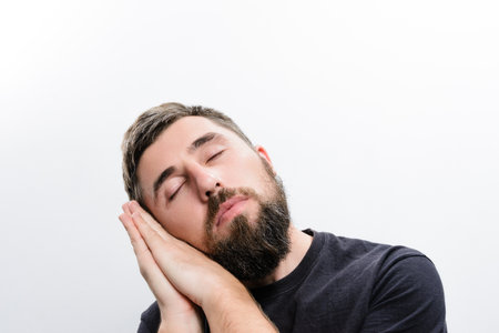 Man sleeping peacefully with hands cupped togetherの写真素材