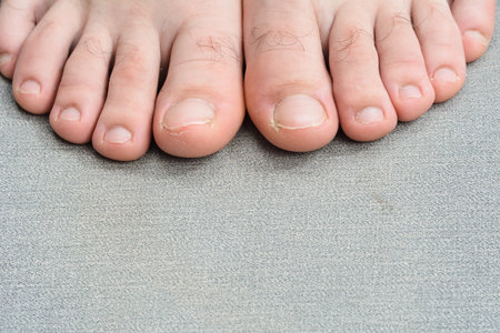 Close-up of bare feet on a gray surface
