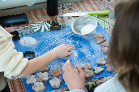 Two individuals, a child and an adult, collaborate in a kitchen setting to make heart-shaped...