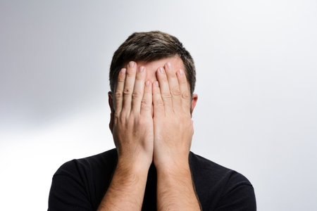 Man covering face with hands