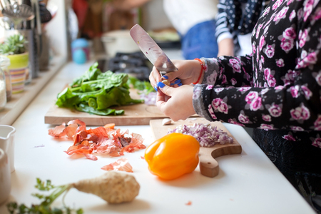 Woman cooking in kitchen with ingredients around herの写真素材