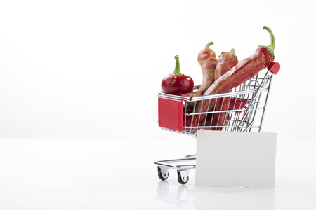 Red hot chili peppers in supermarket trolley isolated on whiteの写真素材